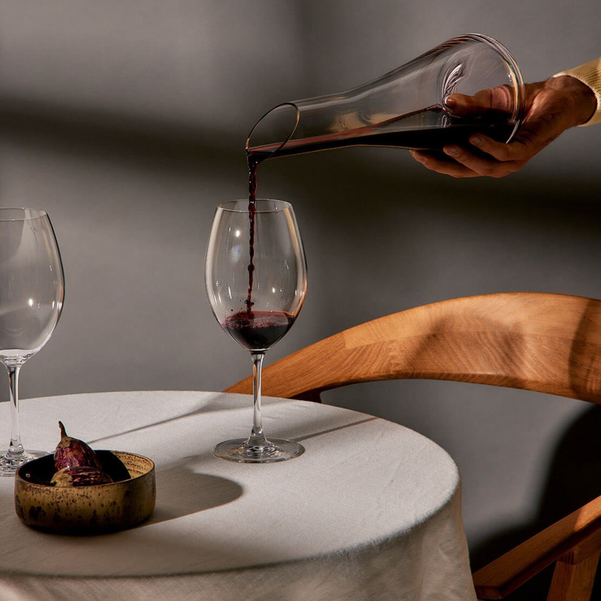 Crystal wine decanters and sculptural glass carafes styled on a modern dining table